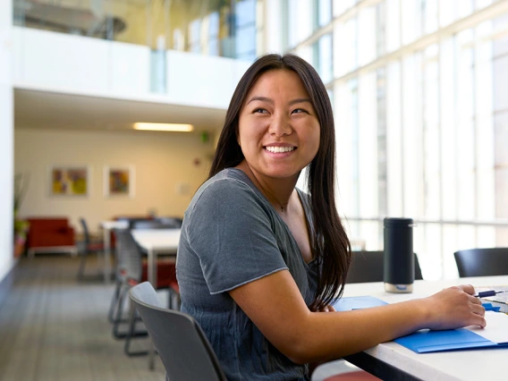 Female asian student smiling and working