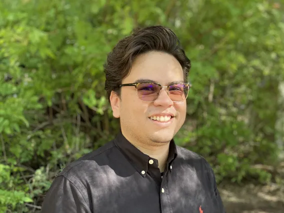 Student headshot with greenery background