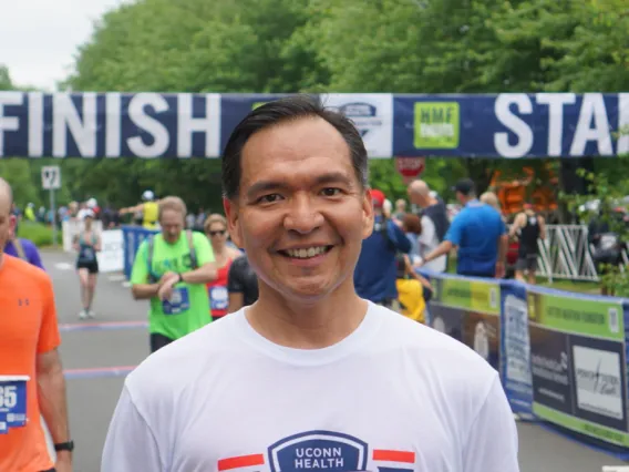 person standing at finish line of race, people in background