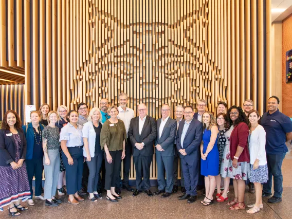 group of people standing in front of wildcat wood art cutout