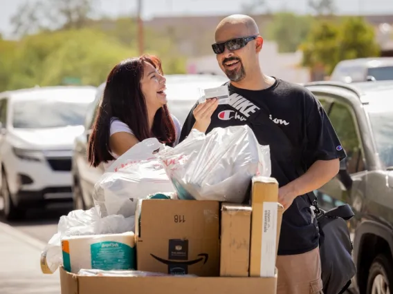 man and woman looking at cat card laughing while moving boxes