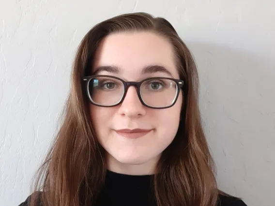 close up headshot of student wearing black with glasses