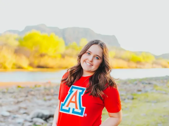 student wearing a red shirt with a landscape background