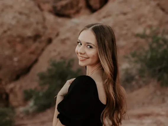 woman wearing black standing in front of red rocks