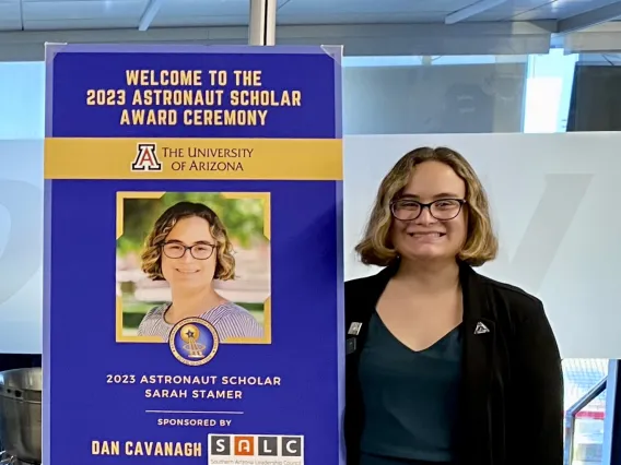 student standing next to sign 