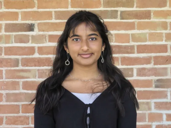 headshot of student with brick background