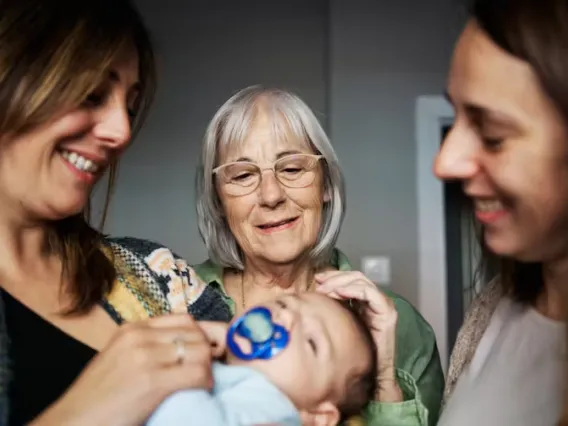 three women looking at baby