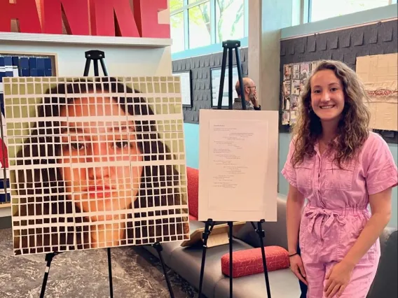 woman standing in front of poster art and poetry