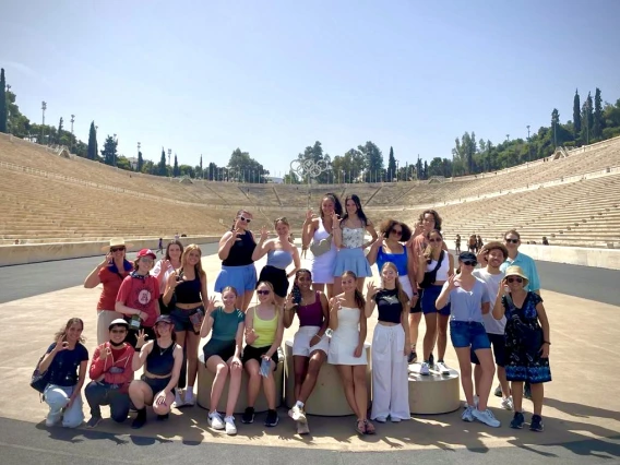 group of students standing in front of olympic stadium in greece