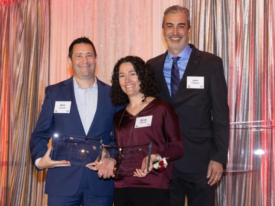 john pollard standing with mark and mindy zeitzer handing them awards