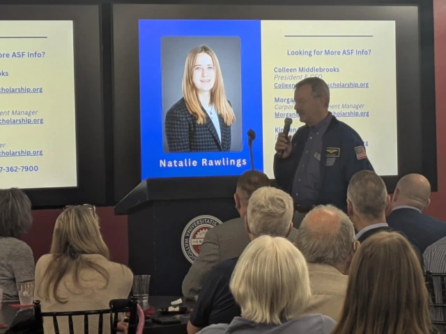 man speaking in front of audience with microphone
