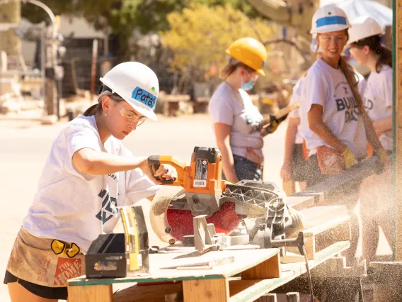 Student using a saw at Honors Build Day 2022