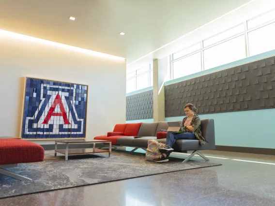 Lounge outside Honors Offices with student on couch