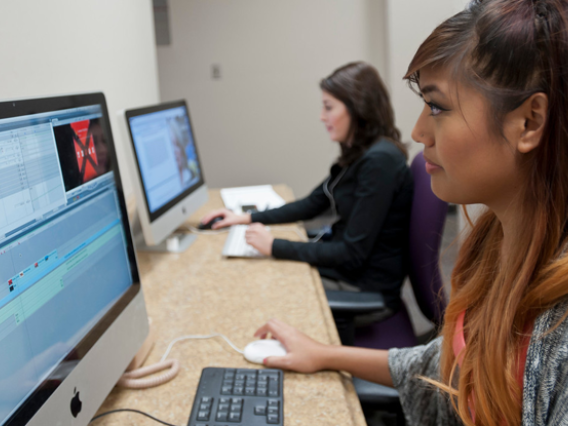 Female student editing video footage on a computer