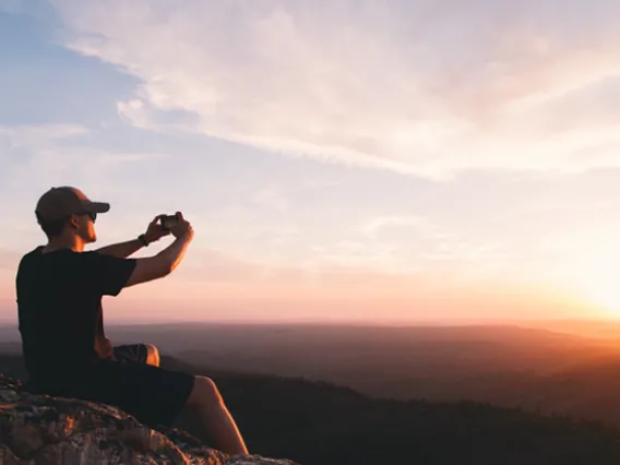 Student taking photo at sunset