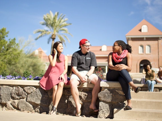 Three students in front of Old Main on UA campus