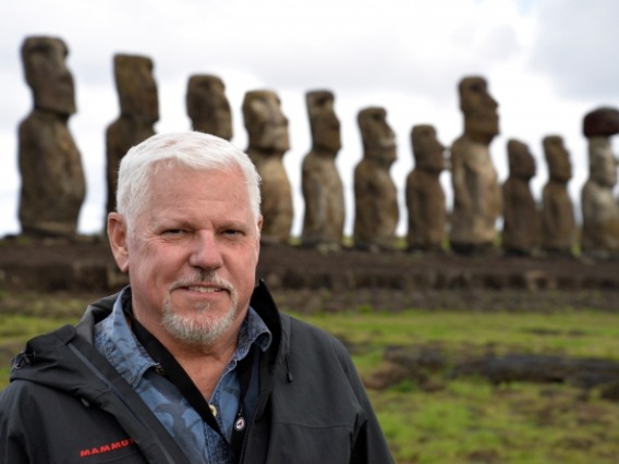 Honors Dean Terry Hunt on Easter Island with moai statues in background.