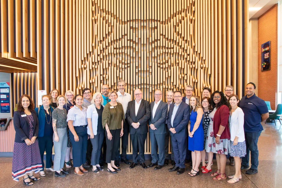 group of people standing in front of wildcat wood art cutout