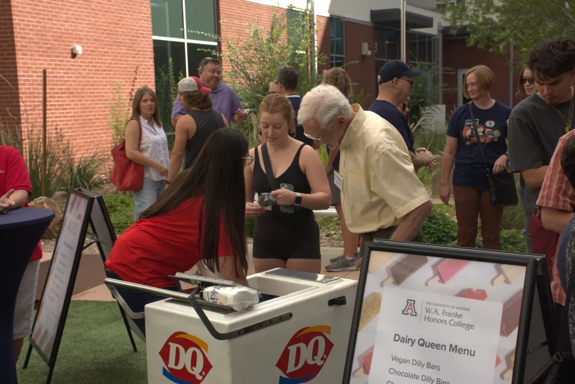 Picture shows W.A. Franke Honors College staff handing out Dairy Queen treats to students and family.