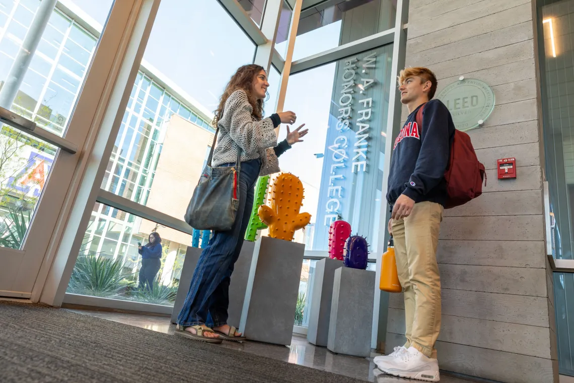 Two students talk in the Honors Village Lobby