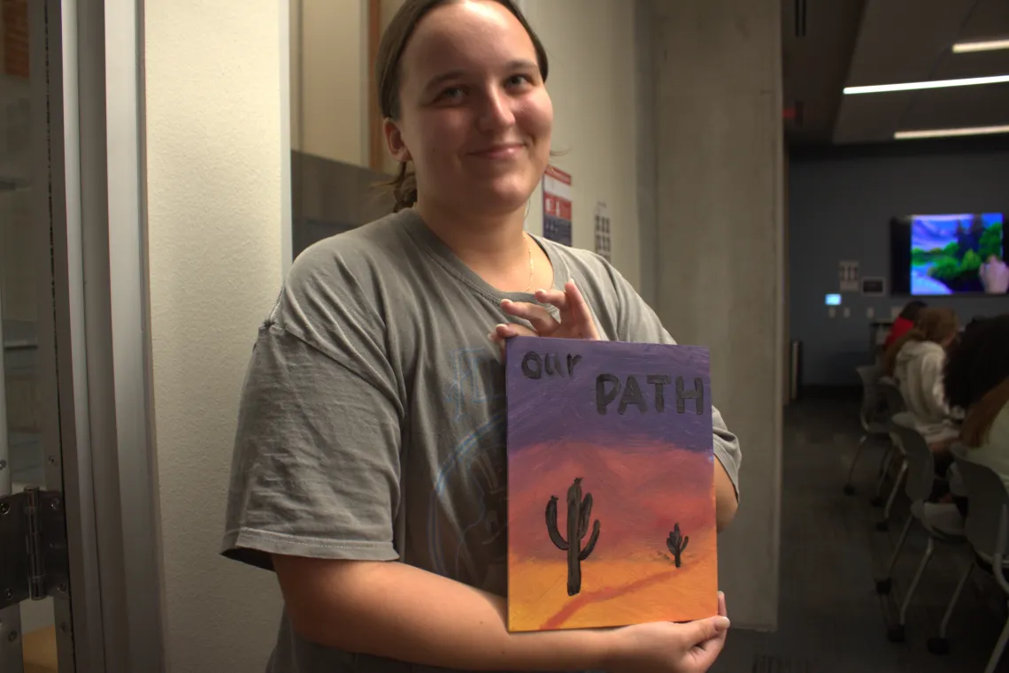 Student with a painting they made.