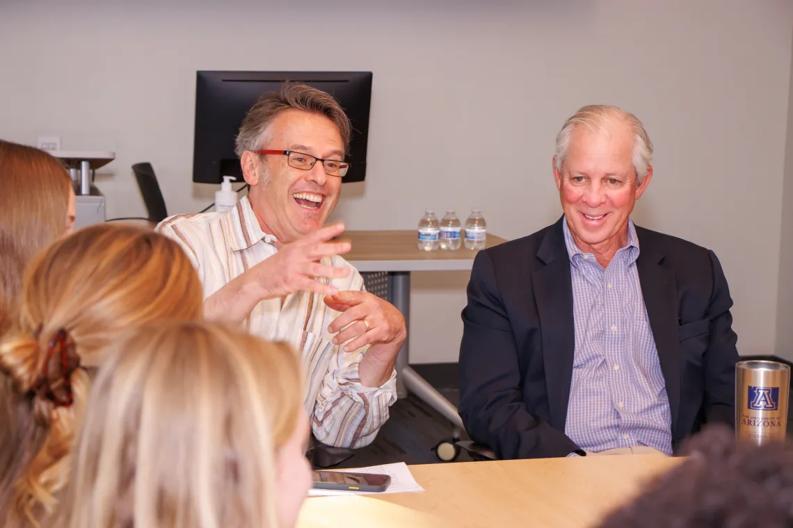 two men in class speaking to students