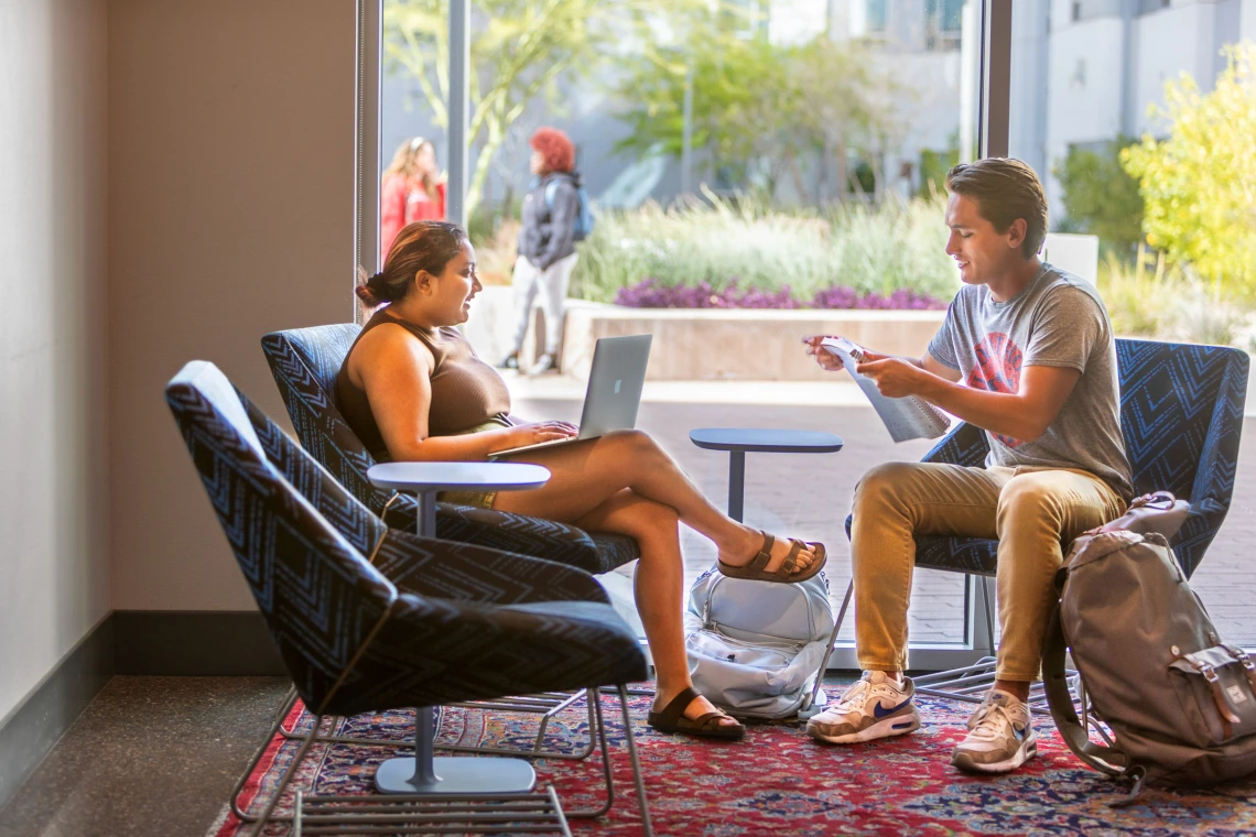 Two students meet in the Honors Village reading nook. 