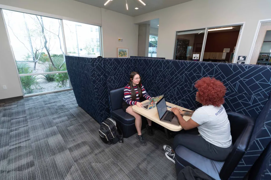 Student studying in academic lounge.