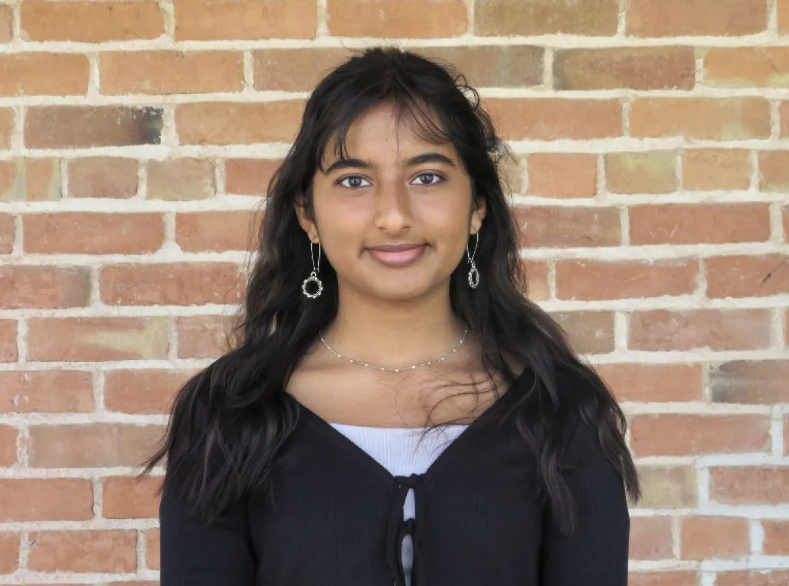 headshot of student with brick background