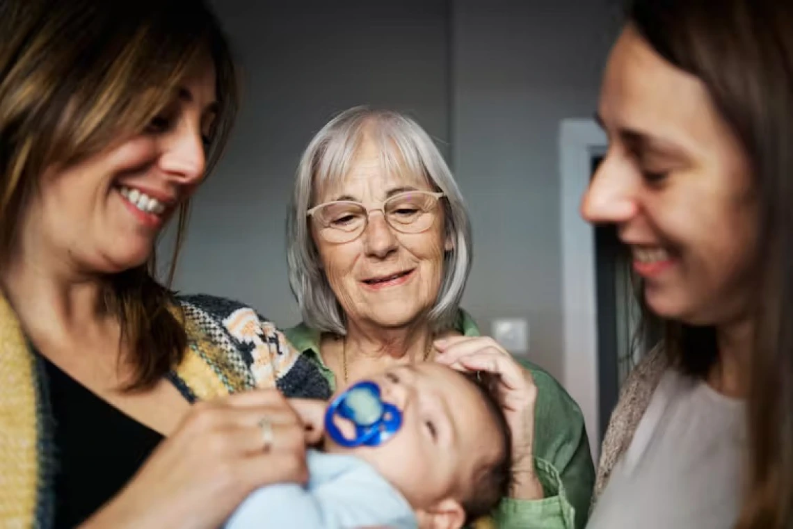 three women looking at baby