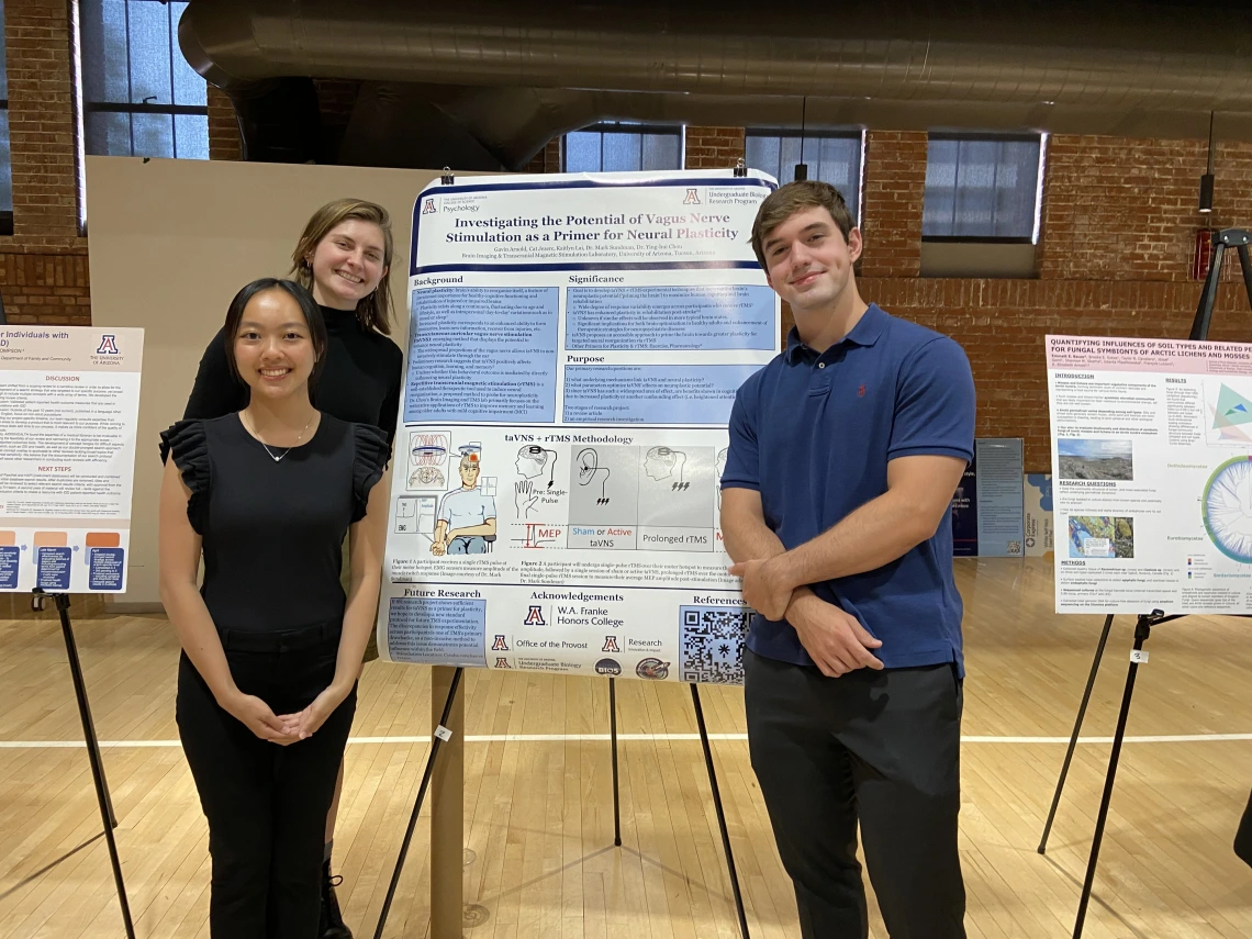 group standing around a poster smiling at camera