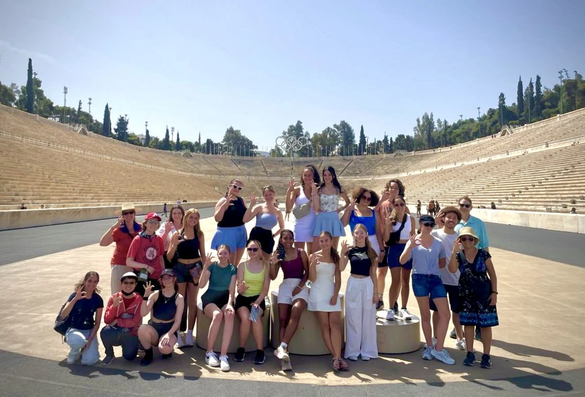 group of students standing in front of olympic stadium in greece