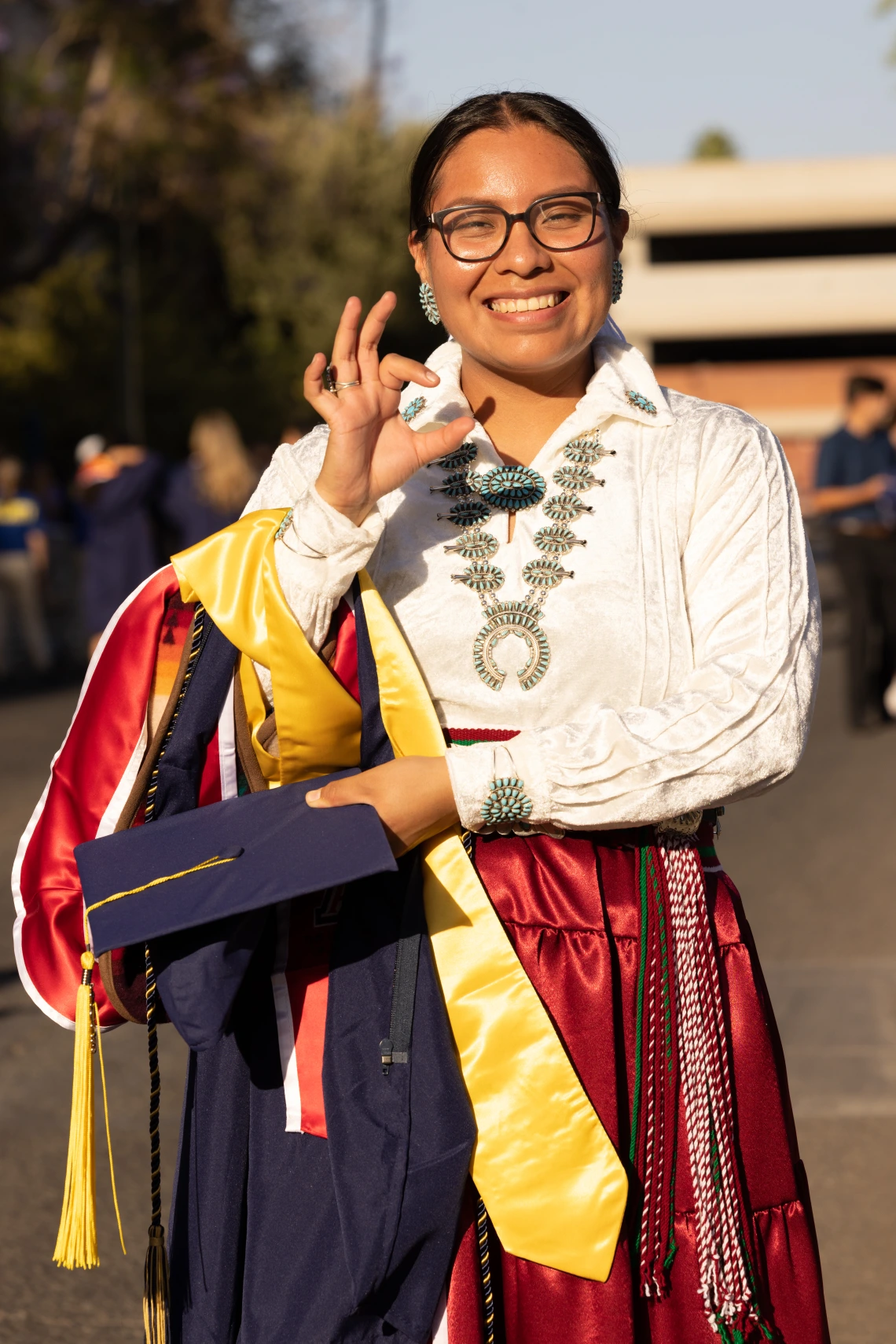 Student at graduation giving the Wildcat sign.