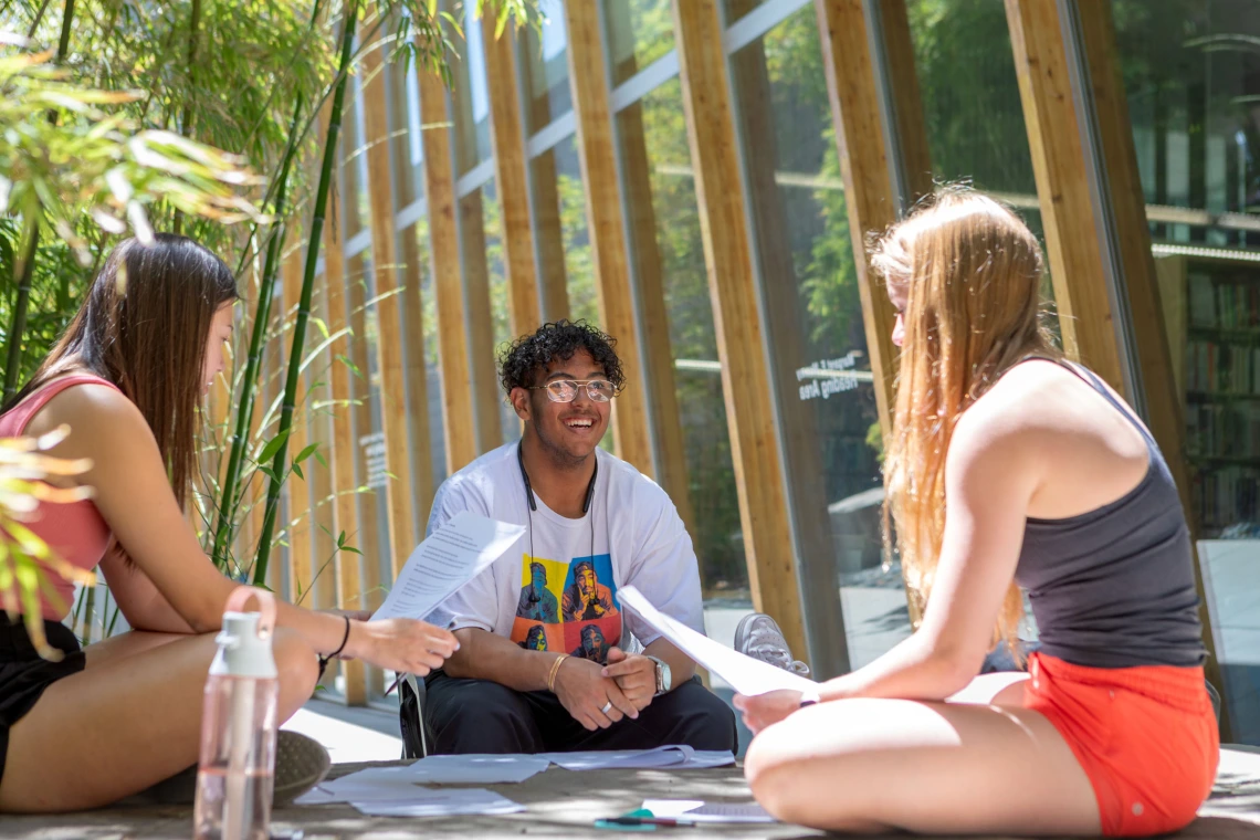 Students sit and talk outside of the Poetry Center