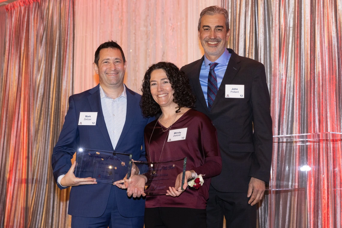 john pollard standing with mark and mindy zeitzer handing them awards