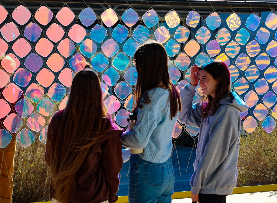 Students stand in front of a piece of art at a visit to Creative Machines