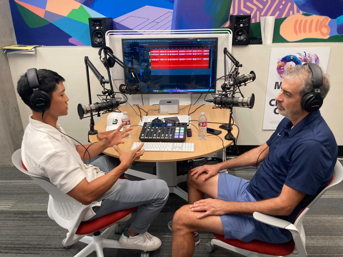 two guests sitting in front of podcast equipment
