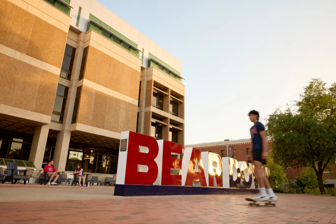 Student walking  in front of main library.