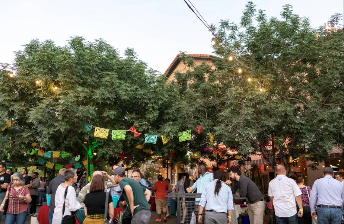 group of people gathered under lights celebrating agave heritage festival