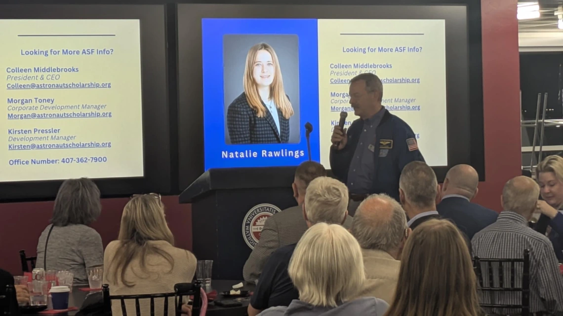 man speaking in front of audience with microphone