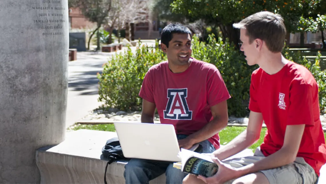 Two students using a laptop