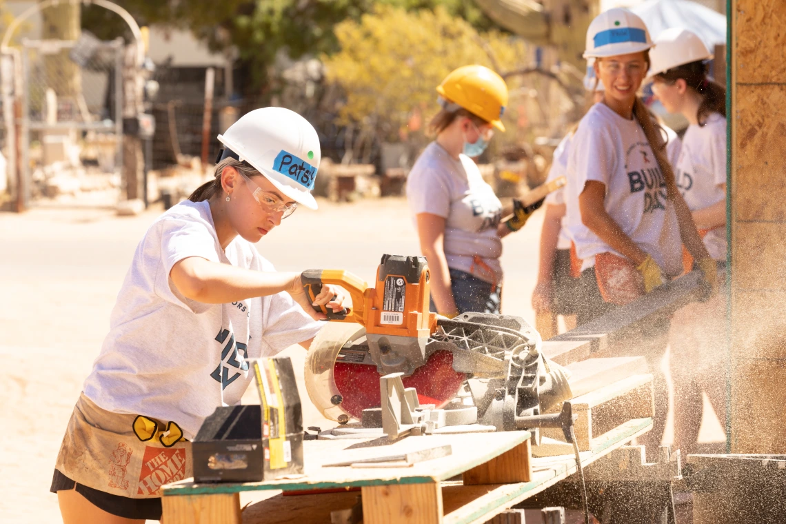 Student using a saw at Honors Build Day 2022