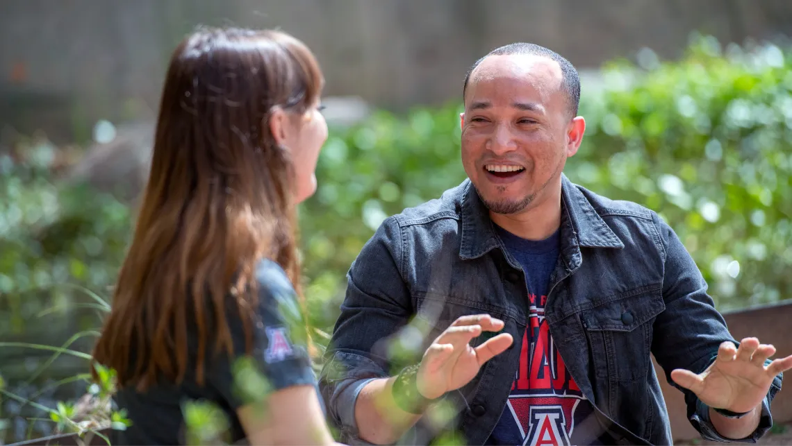 Older advisor excitedly explaining something to a student