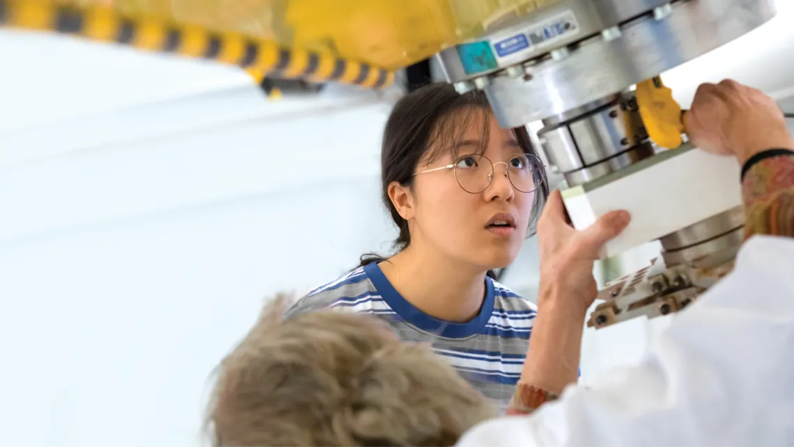 Look of amazement over student's face while he inspects the work of a lab technician