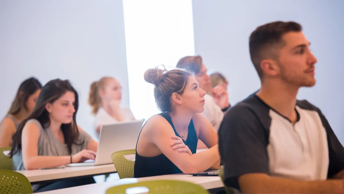 Young people at desks paying close attention to the lecture