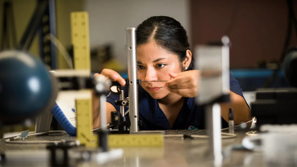 Student taking exact measurement of a metal rod