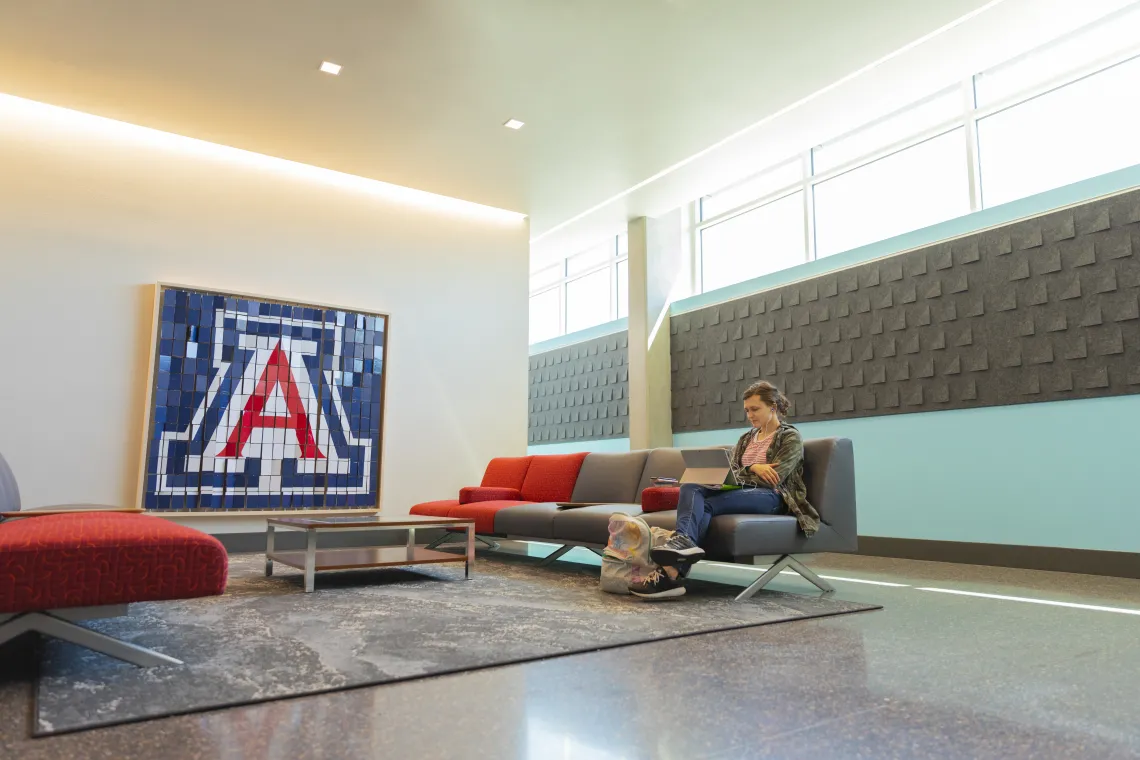 Lounge outside Honors Offices with student on couch