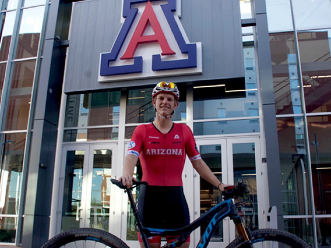 Honors student Spencer Ciammitti on his bike in front of the North Rec