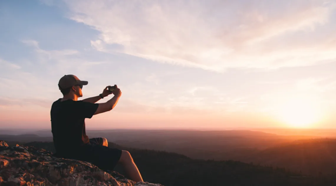 Student taking photo at sunset