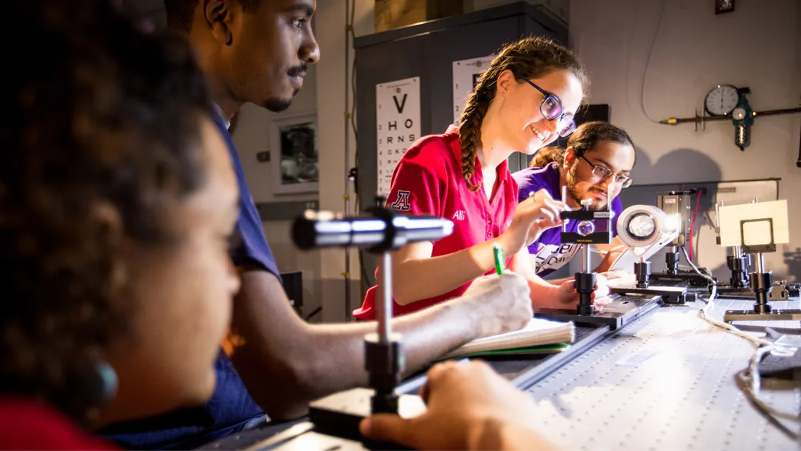 Students configuring lasers in a research lab